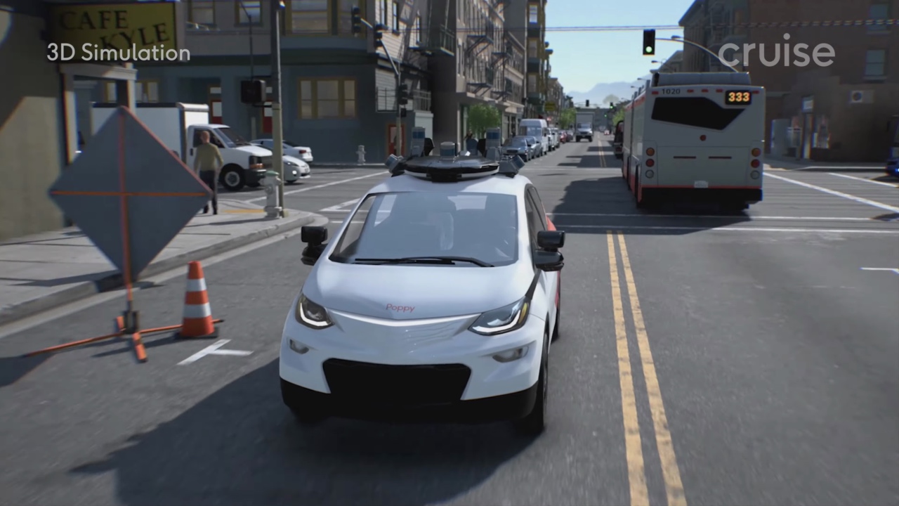 A video game screenshot of a white and orange Cruise autonomous vehicle driving on a street with a bus and a construction sign