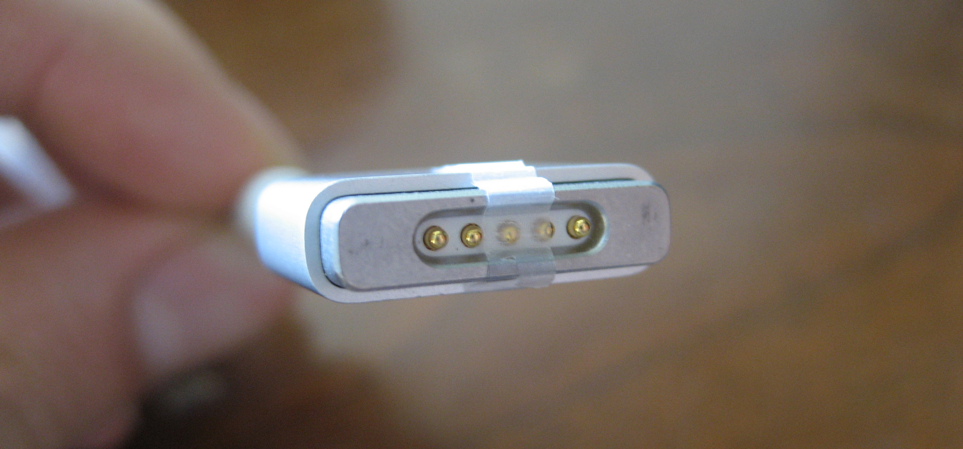 MagSafe charger with the middle pin blocked by a strip of tape